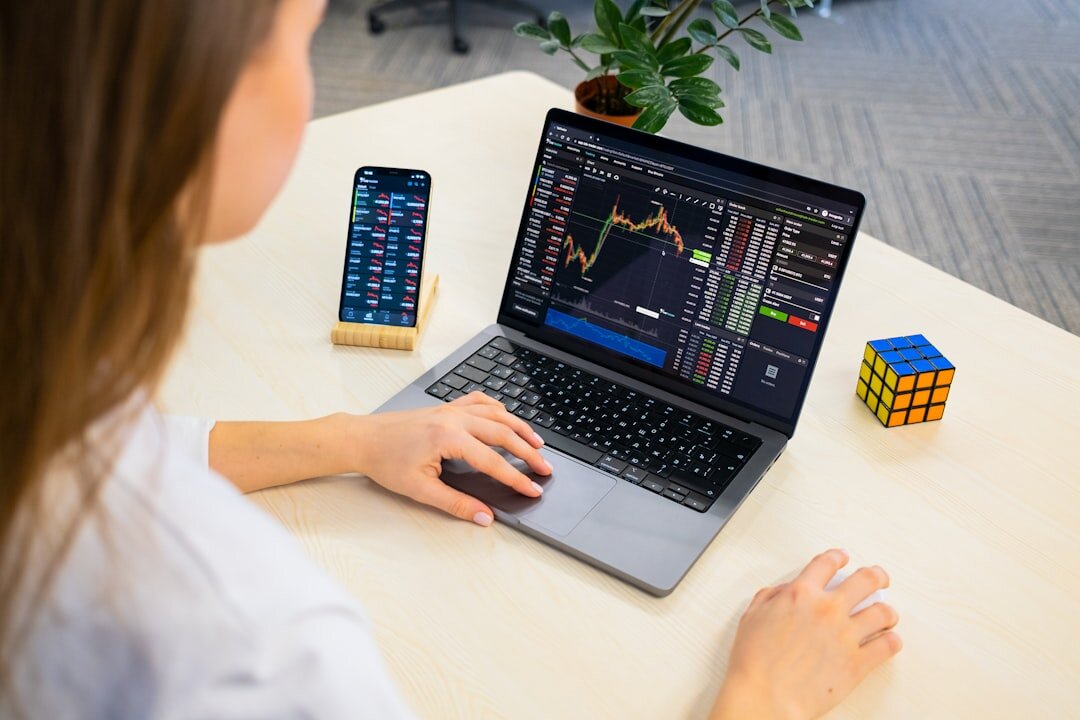 Person analyzing market data charts on a laptop